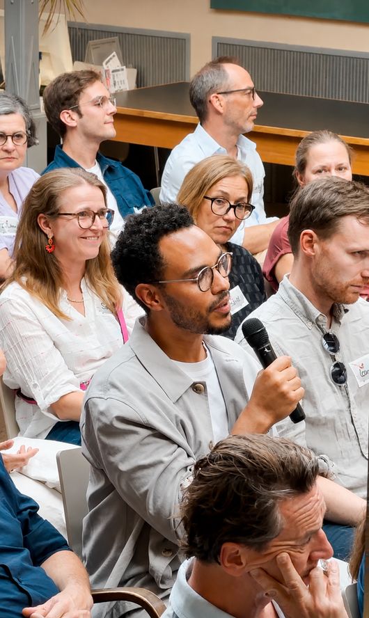 Das Publikum, ein Gast spricht ins Mikrofon